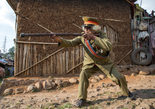 Ethiopian veteran from the italo-ethiopian war in army uniform pretending to shoot, Addis Ababa Region, Addis Ababa, Ethiopia