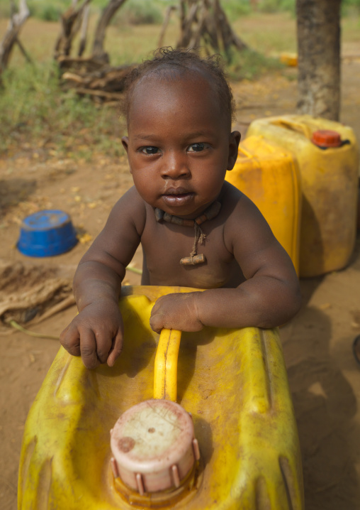 Banna Baby On A Yellow Jerrican Looking At Camera
