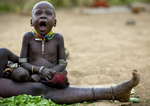 Portrait Of A Tired Nyangatom Baby Yawning, Omo Valley, Kangate, Ethiopia