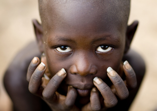 Close-up Portrait Of A Karo Tribe Boy Holding His Head In His Hands, Korcho Village, Omo Valley, Ethiopia