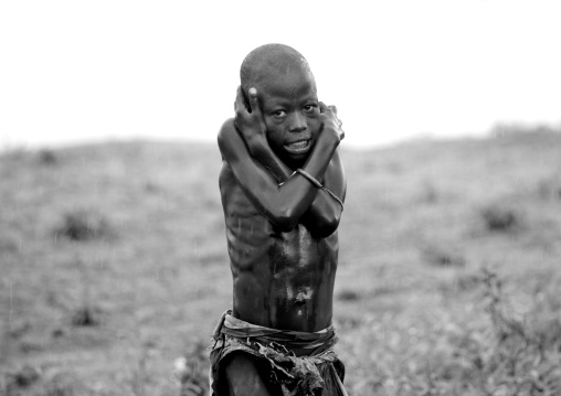 Kid From Karo Tribe Freezing Under The Rain, Korcho Village, Omo Valley, Ethiopia