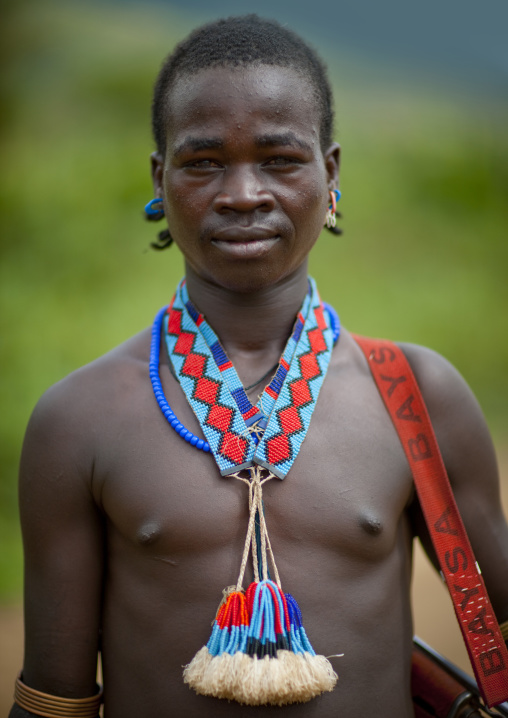 Portrait of a tsemay tribe young man wearing beaded jewels, Omo valley, Ethiopia