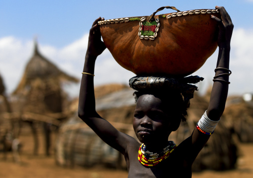 Portrait Of A Dassanech Tribe Girl Holding A Calabash On Her Head, Omorate, Omo Valley, Ethiopia