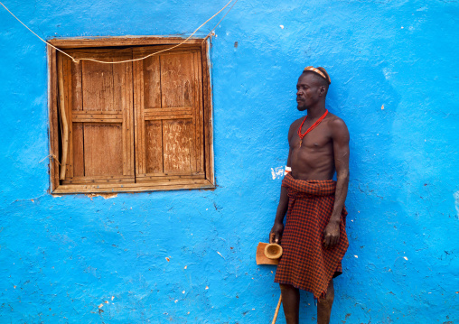 Portrait Of A Dassanech Tribe Man With Headrest Posing Outside A Blue Painted House, Omorate, Omo Valley, Ethiopia
