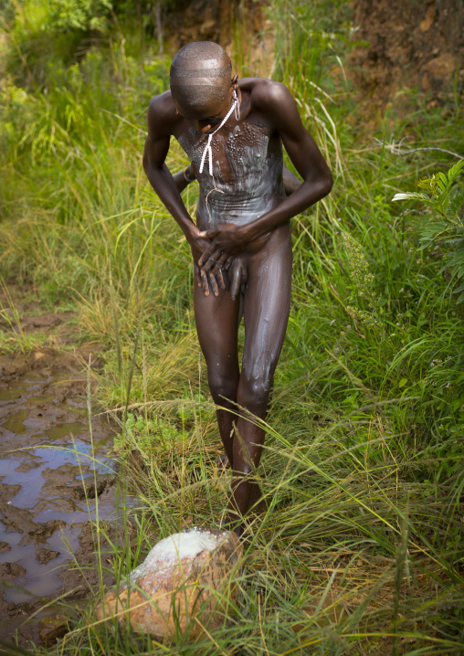 Man from Suri tribe decorating his body with paintings, Tulgit, Omo valley, Ethiopia