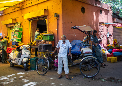 Indian man with his rickshaw in a vegetables and fruits market, Rajasthan, Jaipur, India