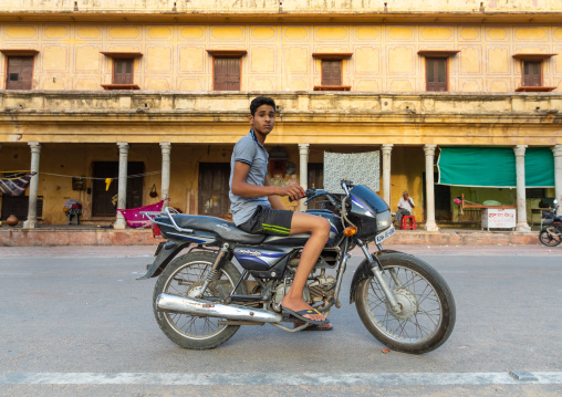 Portrait of a rajasthani teenage boy riding a motorbike, Rajasthan, Jaipur, India