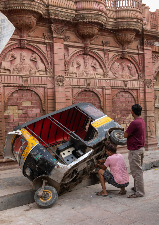 Indian men fixing a rickshaw in the street, Rajasthan, Bikaner, India