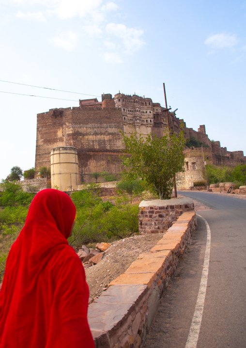 Indian woman walking towards Mehrangarh fort on the hill, Rajasthan, Jodhpur, India