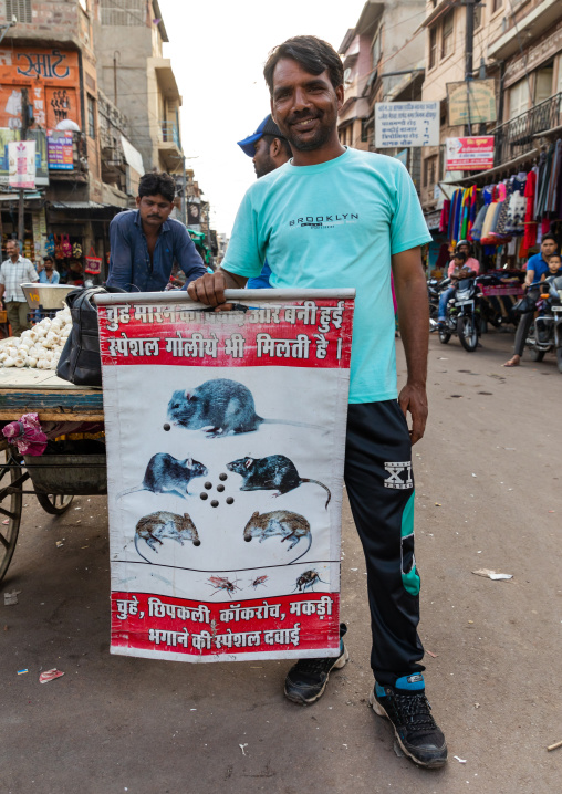 Indian man in the street with a billboard for pest control, Rajasthan, Jodhpur, India