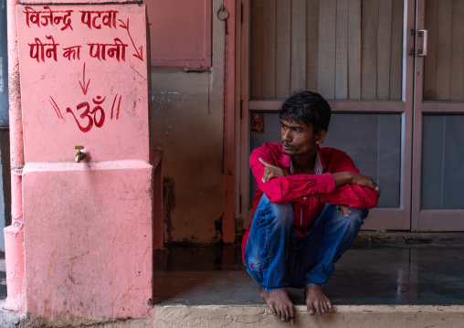 Portrait of an indian man squatting in the street, Rajasthan, Jaipur, India