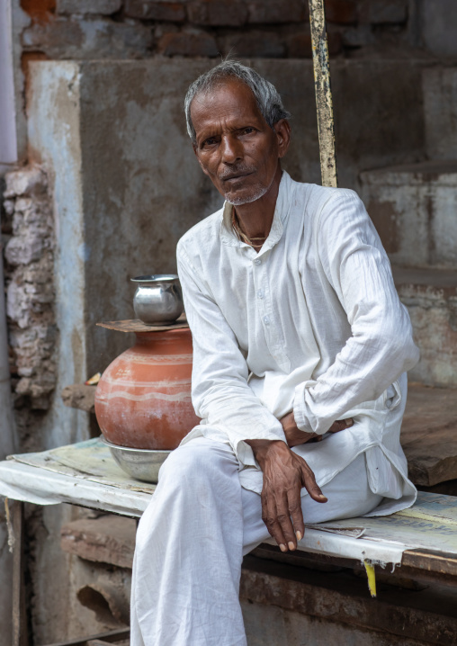 Portrait of an indian man in white clothes sit in the street, Rajasthan, Bundi, India