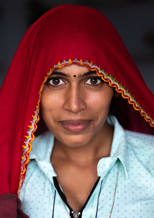 Portrait of a rajasthani woman in traditional red sari, Rajasthan, Baswa, India