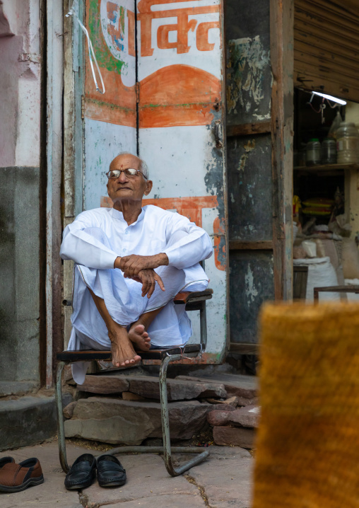 Portrait of an indian man dressed in white in front of his shop, Rajasthan, Jodhpur, India