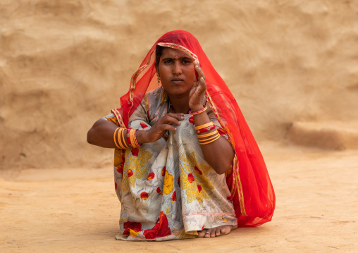 Portrait of a rajasthani woman in traditional red sari, Rajasthan, Jaisalmer, India