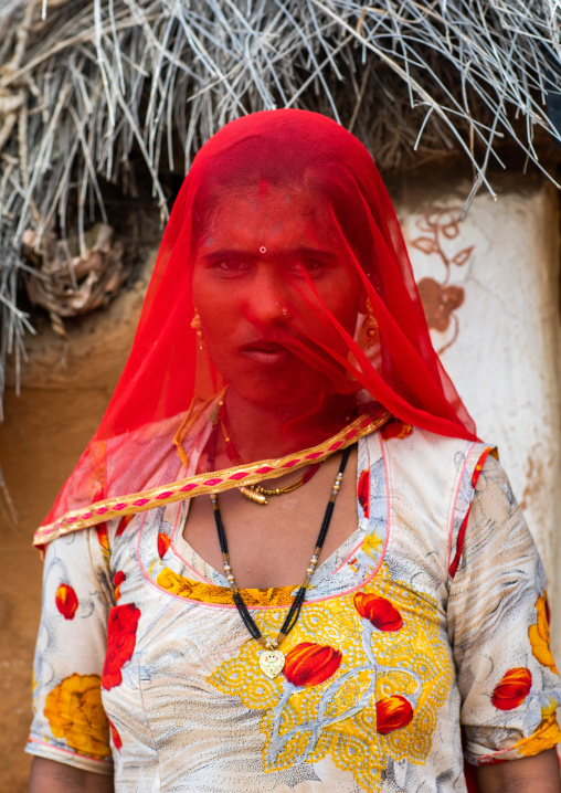 Portrait of a rajasthani woman hidding her face under a red veil, Rajasthan, Jaisalmer, India