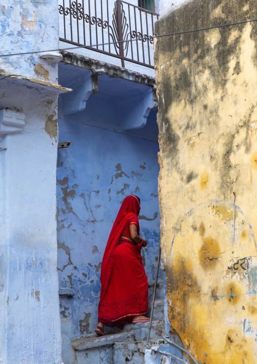 Rajasthani climbing stairs between old houses, Rajasthan, Bundi, India