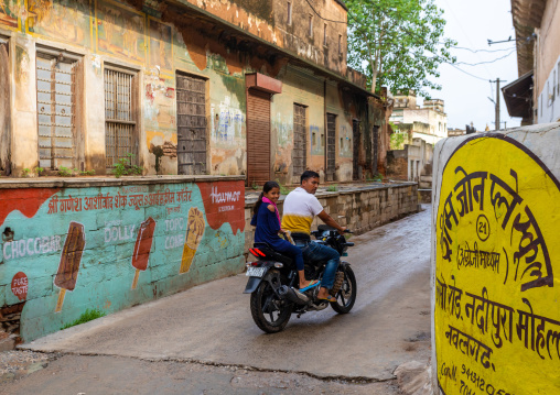 Indian people on a motorbike in front of an old historic haveli, Rajasthan, Nawalgarh, India