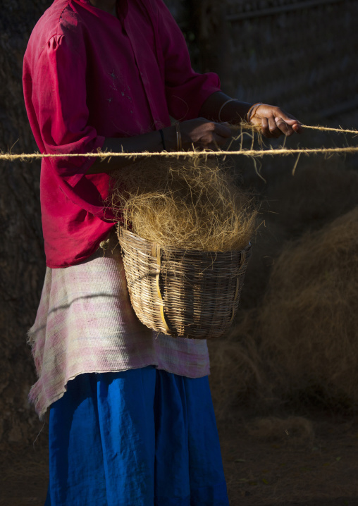 Woman Holding A Basket Full Of Hemps And Making Ropes In A Village Near Madurai, India