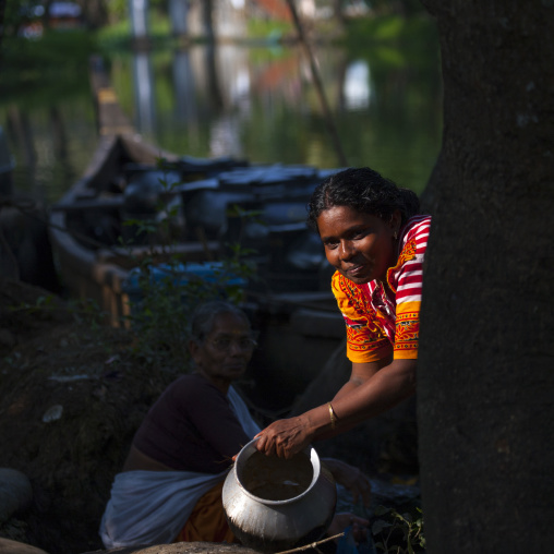 Two Women In Front Of A Rowboat And By The Waterside, Alleppey, India