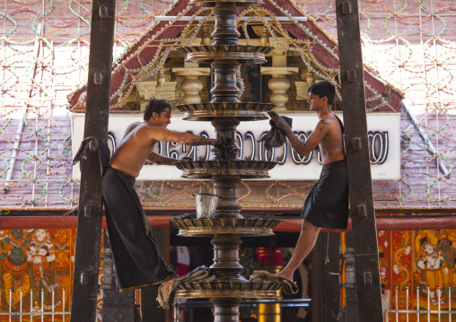 Two Men Cleaning A Lamp At The Entrance Of A Temple, Kochi, India