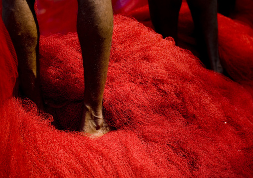 Feet Of Mahe Fishermens Standing On Their Red Nets Nets, India