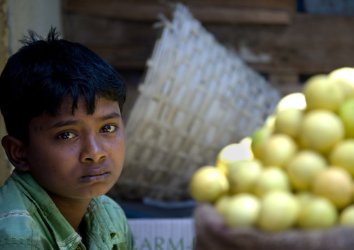 Sad Boy With Eyes Moist With Tears In Front Of A Bag Full Of Lemons At Mysore Market, India