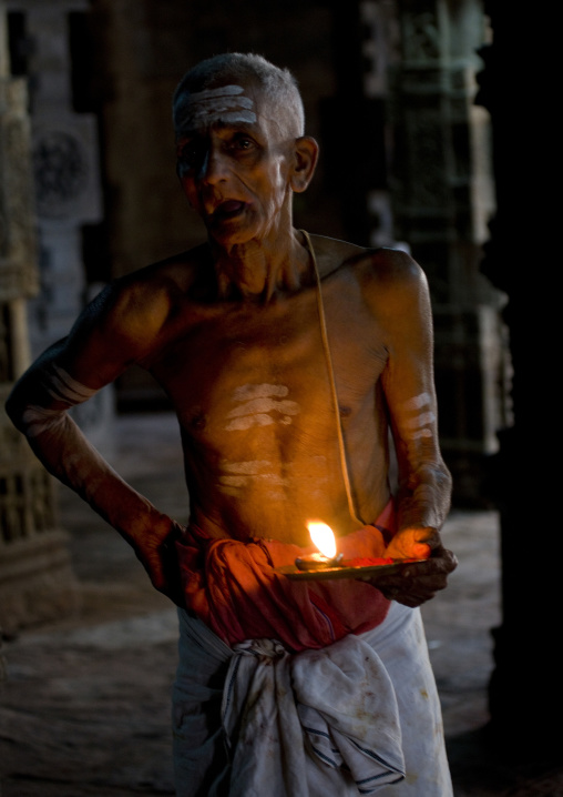 Priest With Traditional Painting On His Forehead Holding A Candle In The Airavatesvara Temple, Darasuram, India