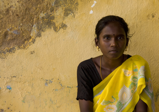 Indian Quiet Teenage Girl Sitting In Front Of A Yellow Decrepit Wall, Kumbakonam, India