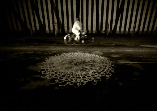 Cyclist Riding Along A Kolam Drawned In The Street Near The Sri Ranganathaswamy Temple, Trichy, India