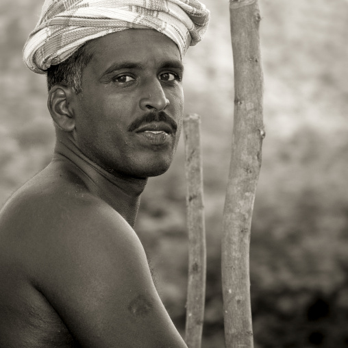 Shirtless Man Wearing A Turban And A Mustache Posing Next To Wooden Stick, Madurai, India