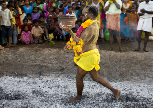 Man Wearing Flower Garland Holding A Jar On Fire Performing A Fire Walking Ritual, In Front Of A Large Audience, Madurai, South India