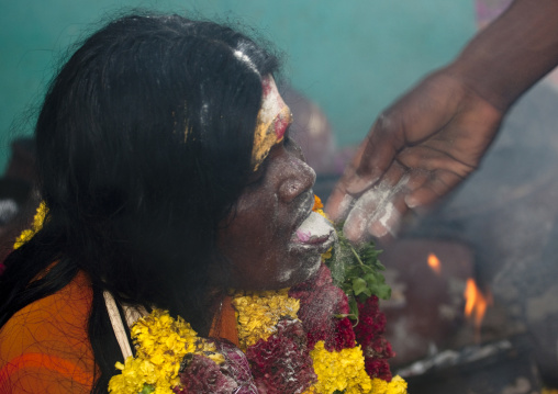 Woman With Traditional Painting On Her Forehead Wearing Flower Garland And Being Sprayed With Ashes At Fire Walking Ritual, Madurai, South India