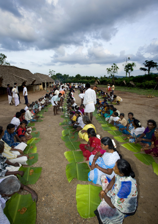 People Sitting On The Ground With A Leaf Serving As Plate During A Collective Meal After Fire Walking Ceremony, Madurai, India