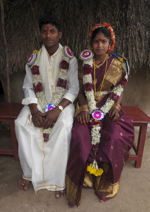 Young Bride And Groom Sitting On A Bank Dressed For The Ceremony And Adorned With Flower Garlands, Pondicherry, India