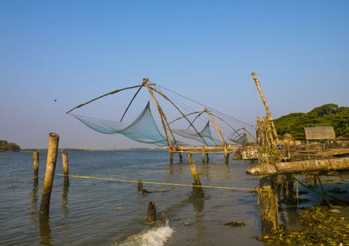 Fishermen Sitting Near Chinese Fishing Nets, Kochi, India