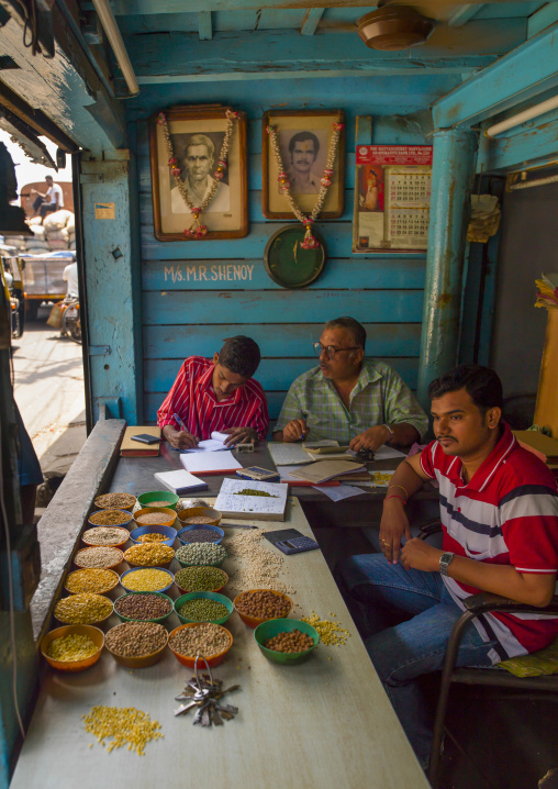 Sellers Of Grains Working On Their Business Behind Their Stalls In Their Store, Kochi, India