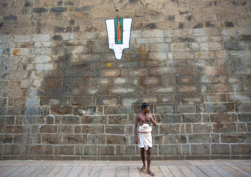 Priest Posing In Front Of A Vaishnava Tilak Painted On A Wall At The Sri Ranganathaswamy Temple, Trichy, India