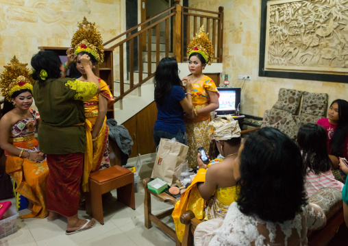 Women Applying Makeup To Teenagers Girls In Traditional  Costumes  Before A Tooth Filing Ceremony