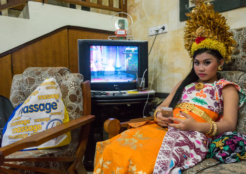 A Teenager Girl In Traditional  Costume Using Her Mobile Phone As A Mirror  Before A Tooth Filing Ceremony