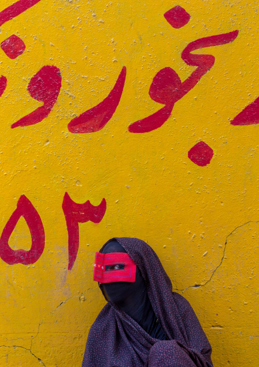 a bandari woman wearing the traditional mask called the burqa on a market, Hormozgan, Bandar Abbas, Iran