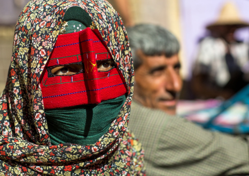 a bandari woman wearing the traditional mask called the burqa on a market, Hormozgan, Bandar Abbas, Iran