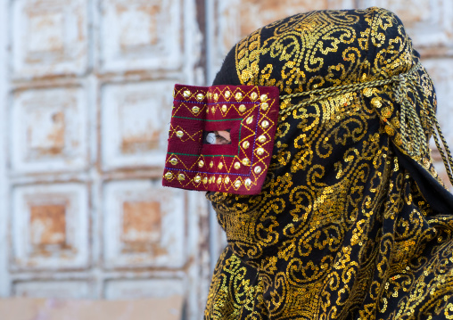 a bandari woman wearing the traditional mask called the burqa on a market, Hormozgan, Bandar Abbas, Iran