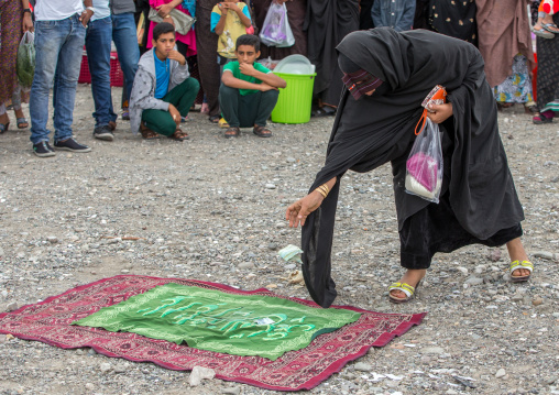 masked woman donating money to the perfomers of a circus, Hormozgan, Minab, Iran