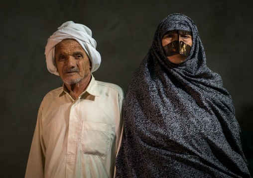a bandari woman wearing a traditional mask called the burqa with her husband, Qeshm Island, Tabl , Iran