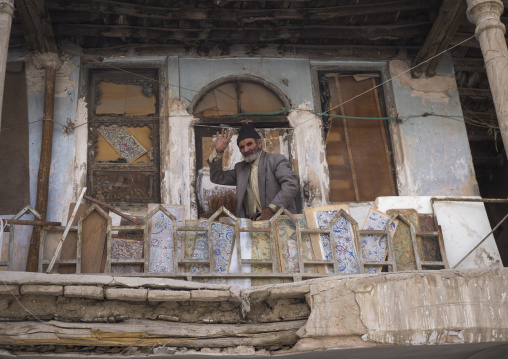 Man waving hello on the balcony of his old house, Isfahan province, Isfahan, Iran