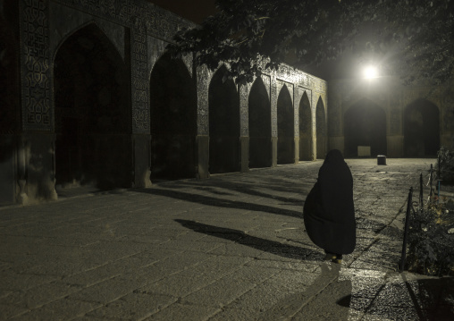 Iranian veiled woman inside sheikh lotfollah mosque at night, Isfahan province, Isfahan, Iran