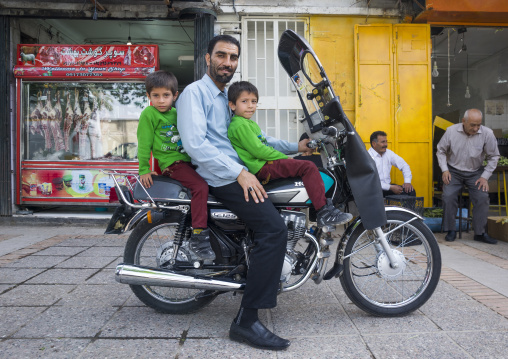 Father with twins on a motorbike, Fars province, Shiraz, Iran