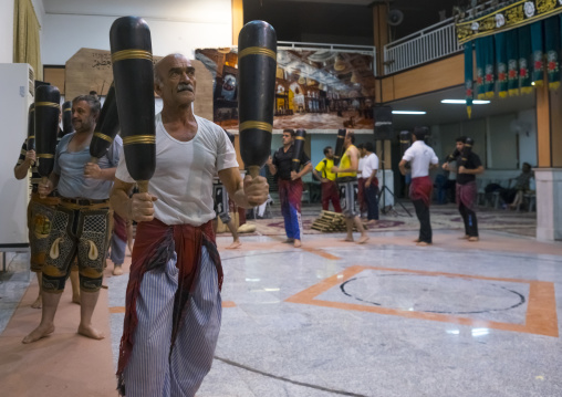 Men wielding wooden clubs during the traditional sport of zurkhaneh, Isfahan province, Kashan, Iran