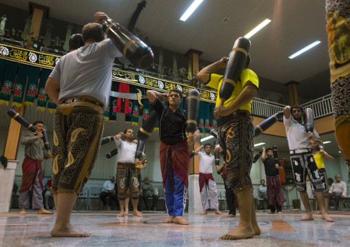 Men wielding wooden clubs during the traditional sport of zurkhaneh, Isfahan province, Kashan, Iran